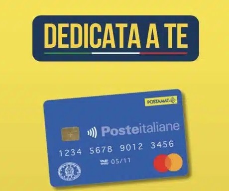 Immagine con sfondo giallo. In alto, una scritta blu con lettere maiuscole gialle recita “Dedicata a te”, sottolineata dai colori della bandiera italiana. Sotto la scritta compare una carta blu di Poste Italiane con il logo “Postamat”, il chip e il logo Mastercard
