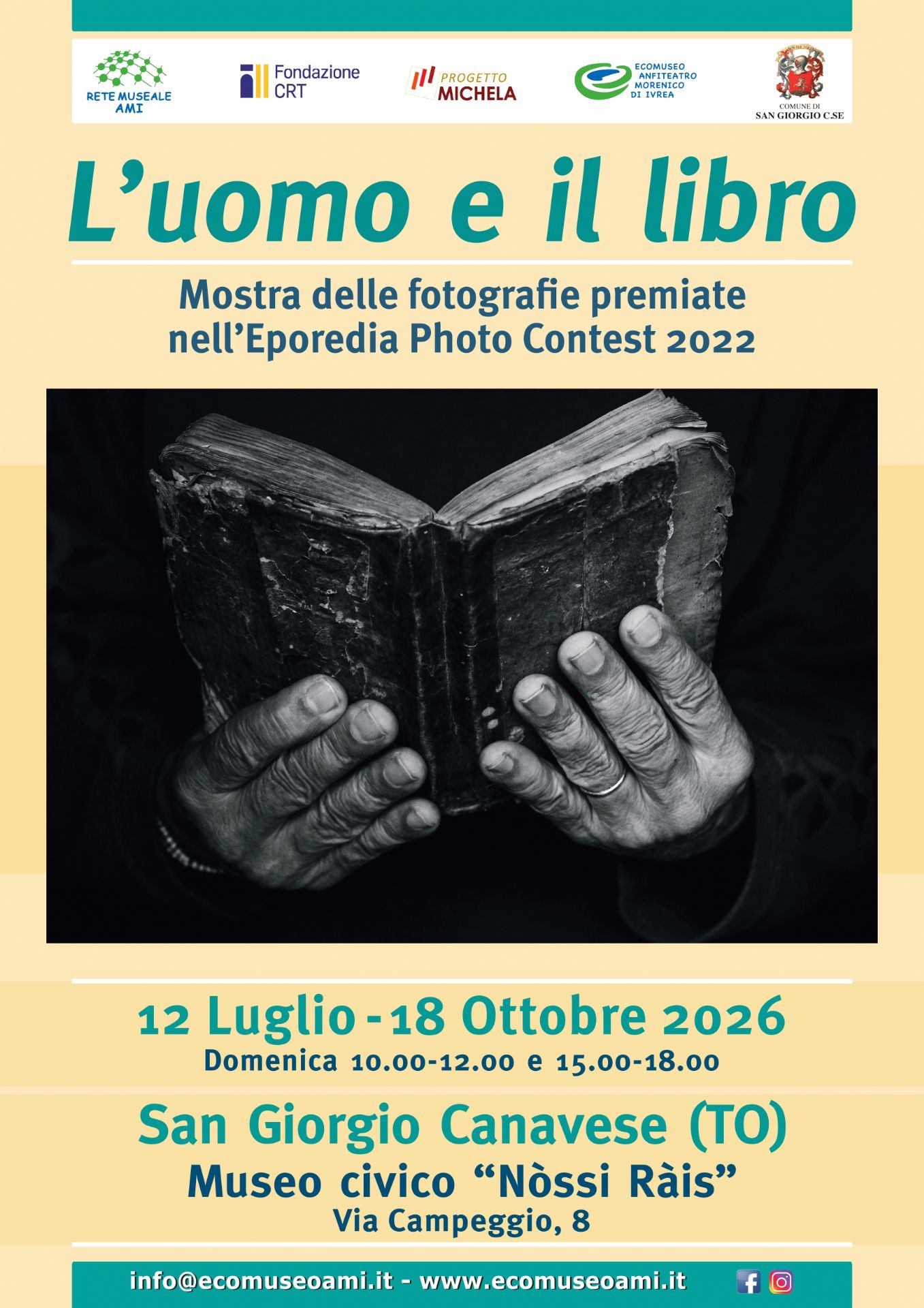 Locandina promozionale della mostra fotografica "L'uomo e il libro", dedicata alle fotografie premiate nell'Eporedia Photo Contest 2022. La grafica presenta, al centro, una fotografia in bianco e nero che ritrae un antico libro aperto sostenuto dalle mani segnate dal tempo di una persona, simbolo del rapporto tra l'uomo e la lettura. Nella parte superiore sono riportati i loghi della Rete Museale AMI, Fondazione CRT, Progetto Michela, Ecomuseo Anfiteatro Morenico di Ivrea e del Comune di San Giorgio Canavese. La mostra è visitabile dal 12 luglio al 18 ottobre 2026 presso il Museo Civico "Nòssi Ràis", in Via Campeggio 8, San Giorgio Canavese (TO), con apertura la domenica dalle 10:00 alle 12:00 e dalle 15:00 alle 18:00. In fondo alla locandina sono riportati i contatti dell'Ecomuseo AMI e i riferimenti ai canali social.